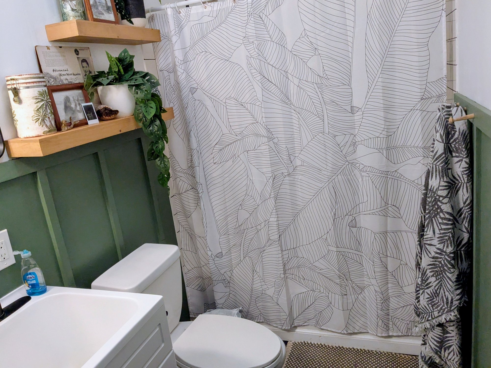 Bathroom with green wainscoting and leaf shower curtain
