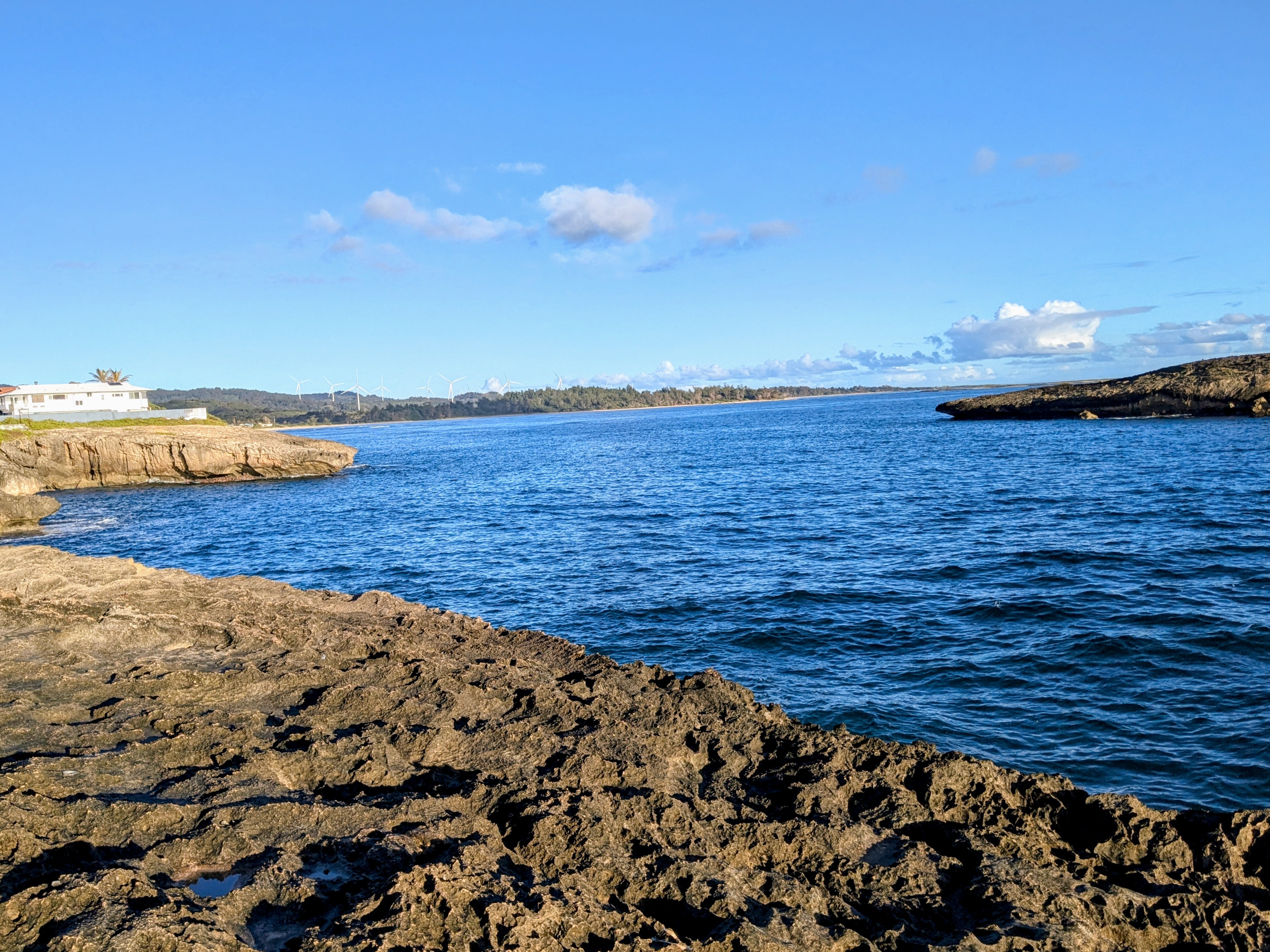 Rocky shoreline at Laie Point with houses on the bluff